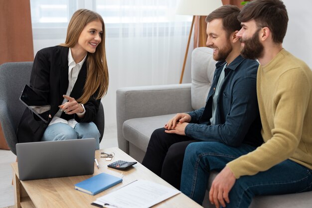 Female real estate agent talking business and showing house to gay couple