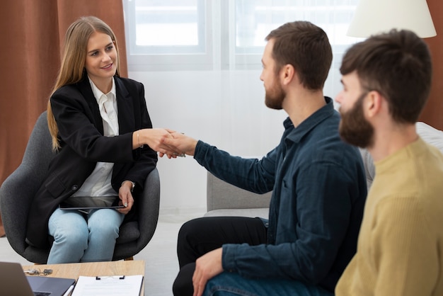 Female real estate agent talking business and showing house to gay couple