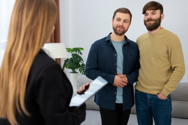 Female real estate agent talking business and showing house to gay couple