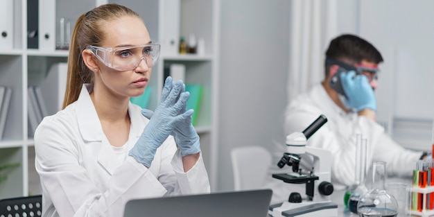 Женский исследователь в лаборатории с защитными очками