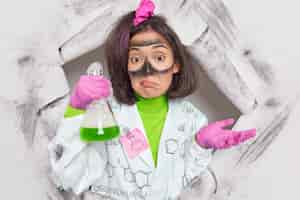 Free photo female researcher studies chemical reactions being unaware why got such explosion of reagents develops new products in laboratory poses through paper hole dressed in uniform