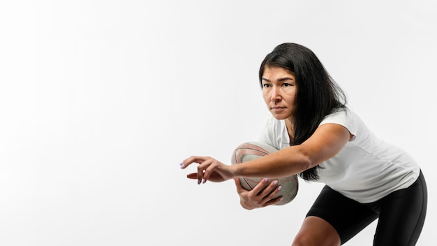 Female rugby player holding ball with copy space