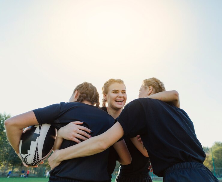 Free Photo female rugby players embracing each other