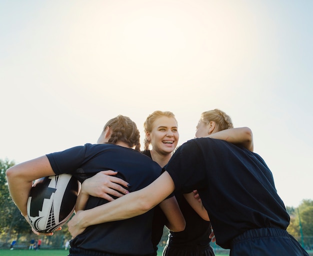 Female rugby players embracing each other