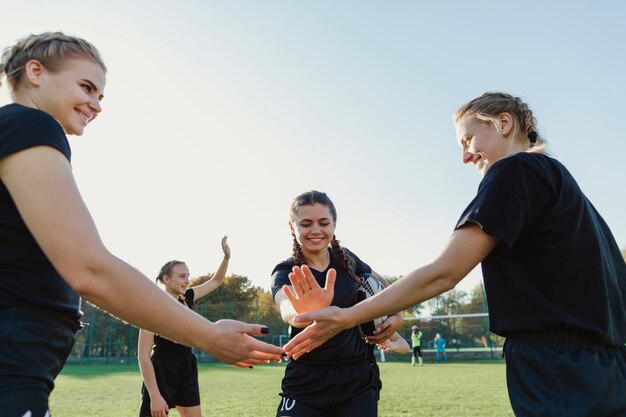 Female rugby players putting hands together