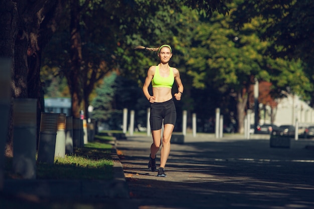 Female runner, athlete training outdoors in summer's sunny day.