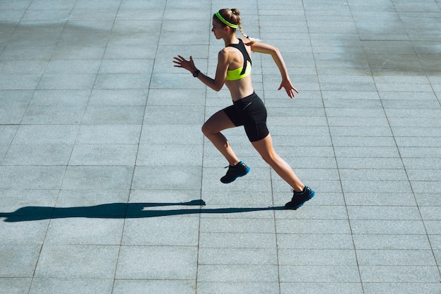 Foto gratuita corridore femminile, atleta che si allena all'aperto nel giorno soleggiato dell'estate.