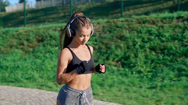 ヘッドホンをつけたスタジアムでの女性ランナートレーニング