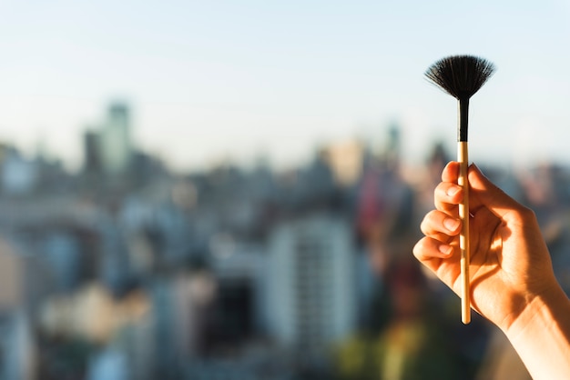 Female's hand holding make-up brush