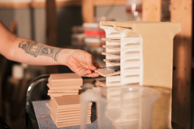 Female's hand taking out the arranged tiles from rack