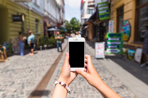 女性の手の通りで携帯電話で写真を撮る