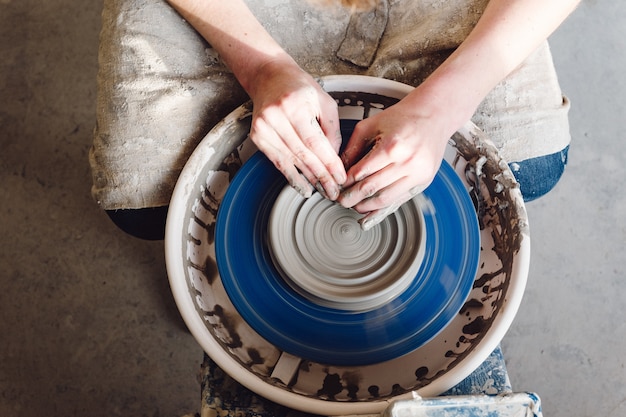 female's hands practicing ceramic pottery