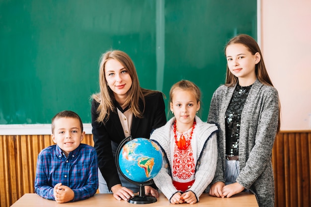 女性の学校の先生と地球に立つ学生