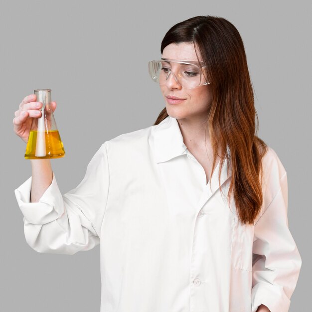 안전 안경을 착용하는 동안 테스트 튜브를 들고 여성 과학자