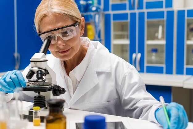 Female scientist looking through the microscope in the lab