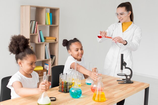 Female scientist teaching girls chemistry