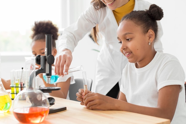 Female scientist teaching young girls about chemistry