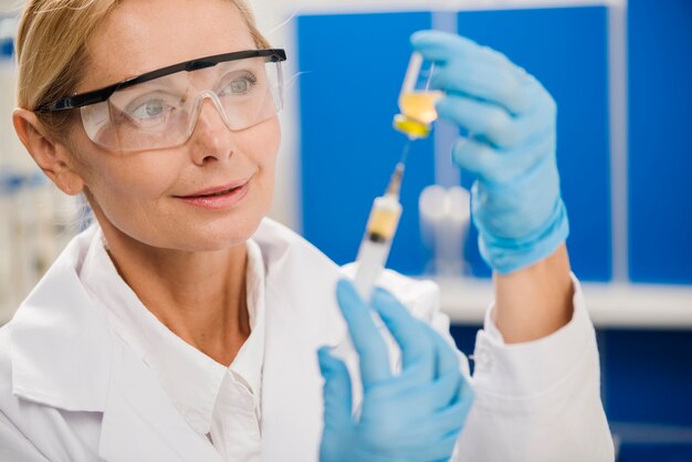 Female scientist using a syringe