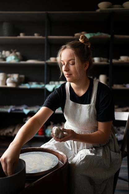 Female sculptor working with clay in the studio