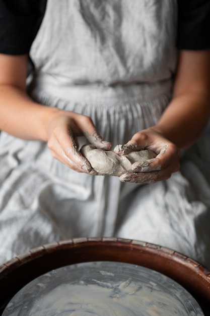 Женщина-скульптор работает с глиной в студии