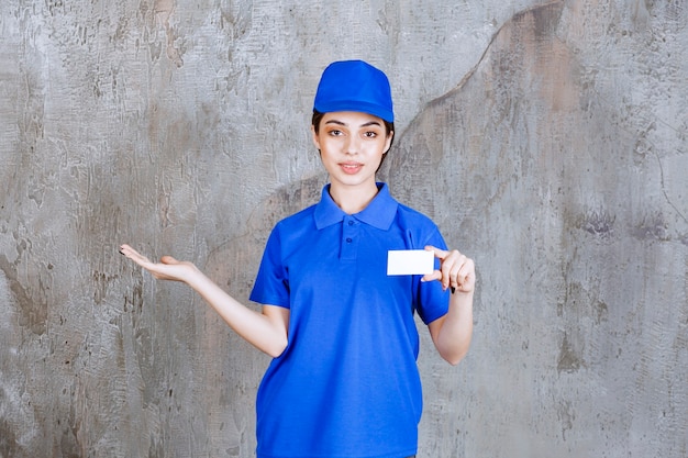 名刺を提示し、同僚を指差す青い制服を着た女性サービスエージェント。