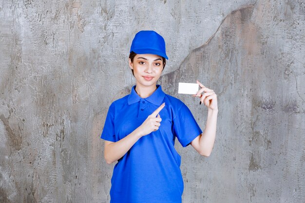 Женский агент службы в синей форме, представляя ее визитную карточку.