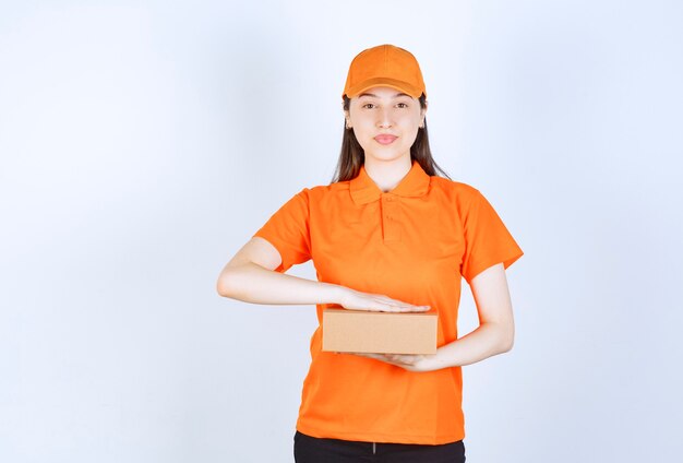 Female service agent in orange color dresscode holding a cardboard box