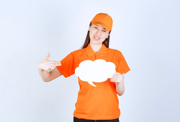 구름 모양 정보 보드를 들고 있는 주황색 드레스코드의 여성 서비스 에이전트