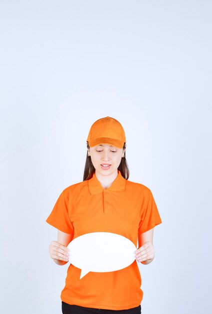 Female service agent in orange color dresscode holding an ovale info board