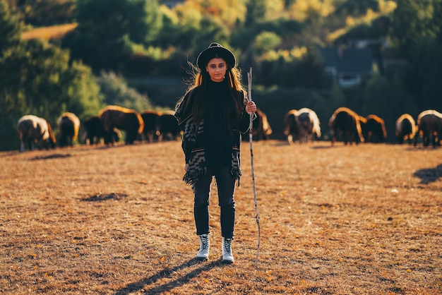 Free photo female shepherd and flock of sheep at a lawn