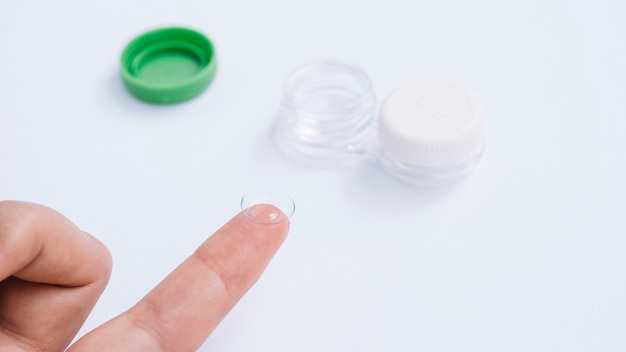 female showing contact lenses on his finger