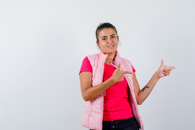 Female showing gun gesture in t-shirt, vest and looking confident 