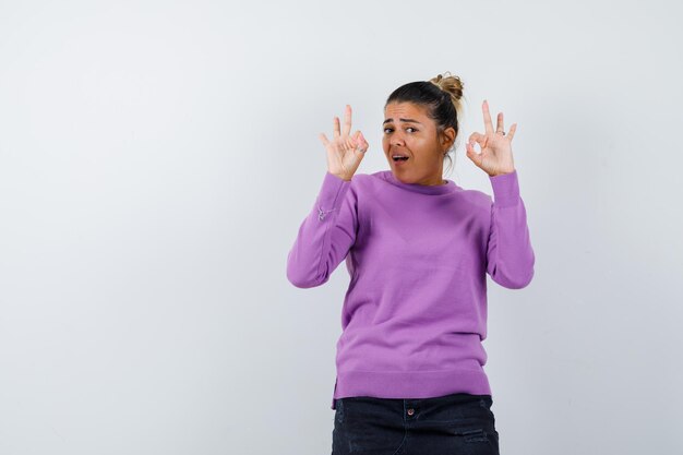 Female showing ok gesture in wool blouse and looking confident