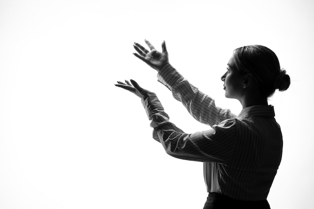 Female silhouette in strict clothing shadow back lit white background young