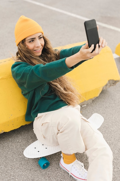 Female on skateboard taking selfie