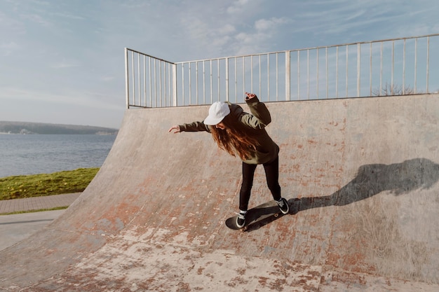 Foto gratuita skateboarder femminile che utilizza rampe per i trucchi