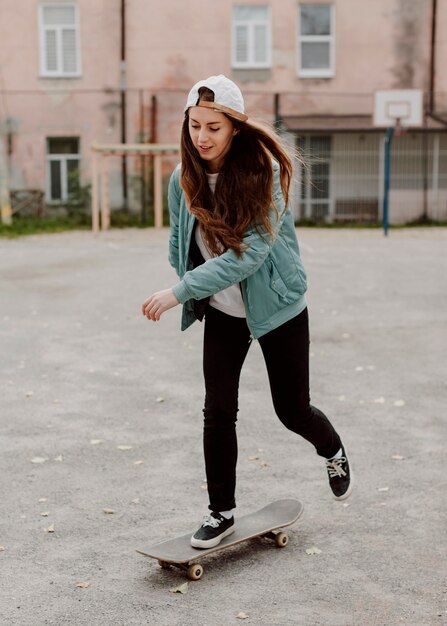 Female skater practicing skateboarding outdoors