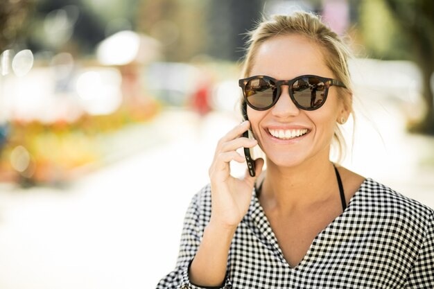 Женщина улыбка красивый сотовый телефон зубы лето