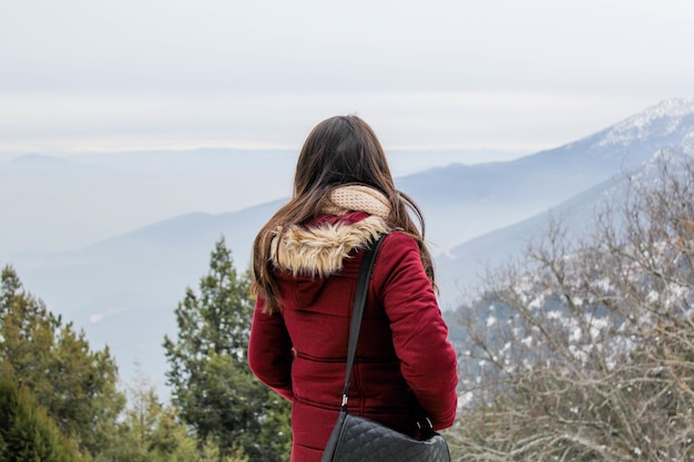 Female in snow with trees and mountains on background