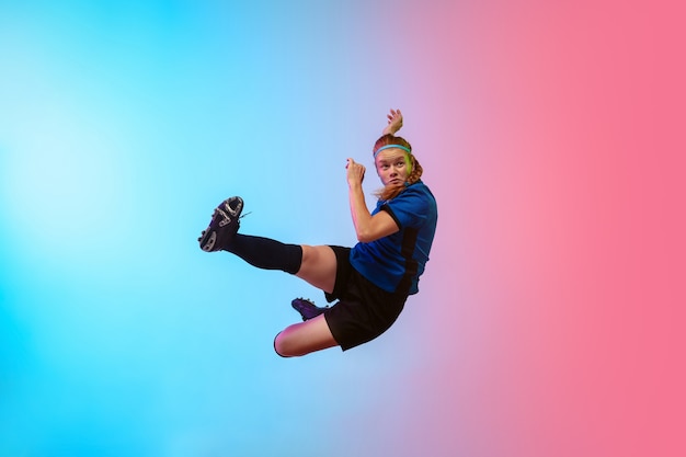 Female soccer, football player training on neon wall, youth