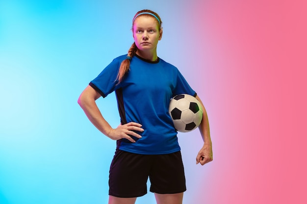 Female soccer, football player training on neon wall, youth