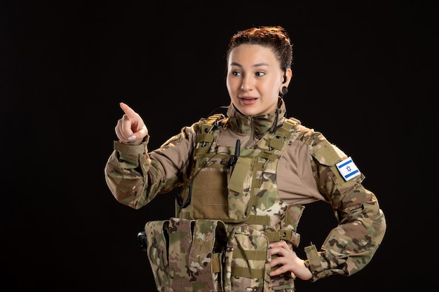 Free photo female soldier in camouflage on the black wall