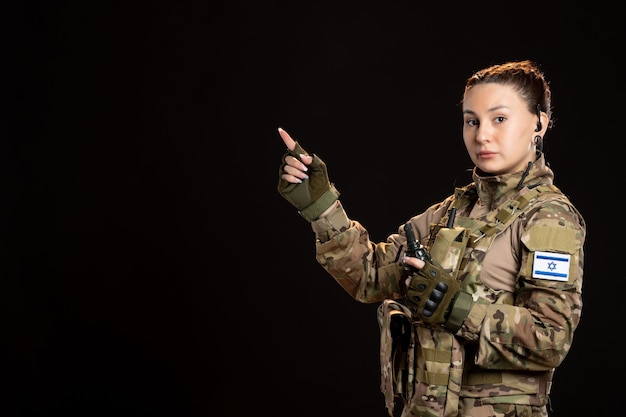 Free photo female soldier in camouflage with grenade on black wall