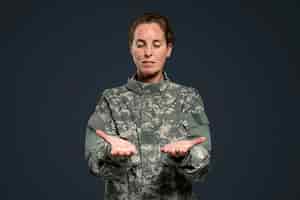 Бесплатное фото Женщина-солдат, представляя невидимый объект