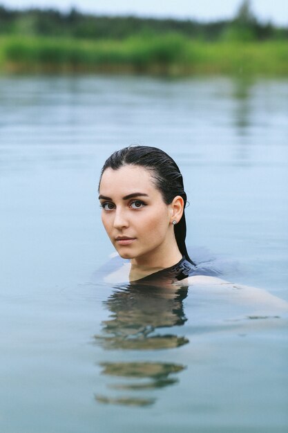 Спортсменка купается в озере