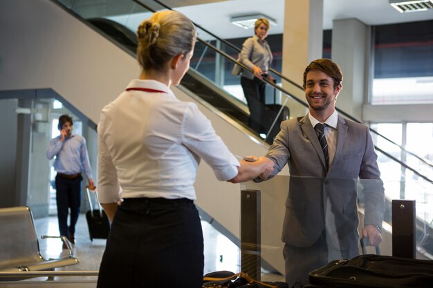 체크인 카운터에서 승객의 탑승권을 확인하는 여성 직원