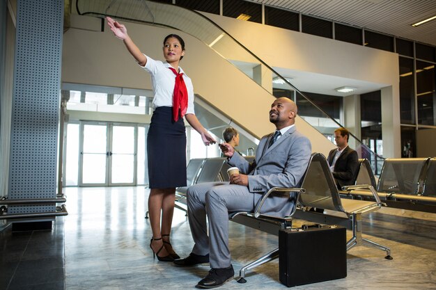 Female staff showing directions to businessman