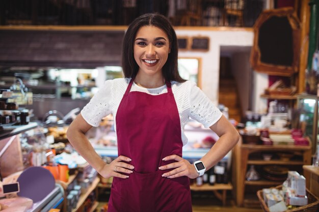 Female staff standing with hand on hip in super market