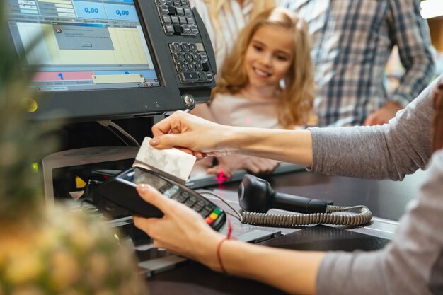 현금 카운터에서 신용 카드 단말기를 사용하는 여성 직원