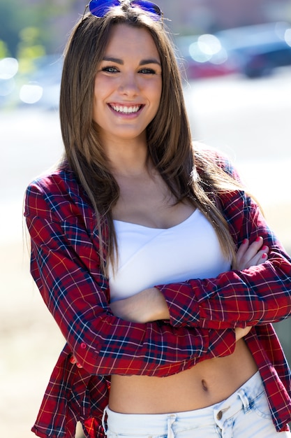 Female standing on street crossing arms